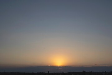 Beautiful sunset in the city with clouds and sun rays. The sun sets over the city.