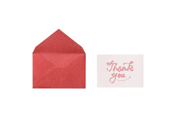 Overhead view of a cutout of a red lamé envelope with a pink handwritten thank-you card placed...