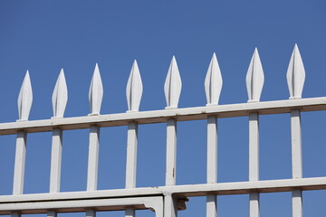 A white fence with sharp spikes on top, used for security or protection
