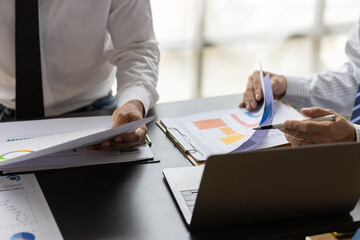 Business consultant analyzing financial charts and graphs on desk. Businesspeople having a...