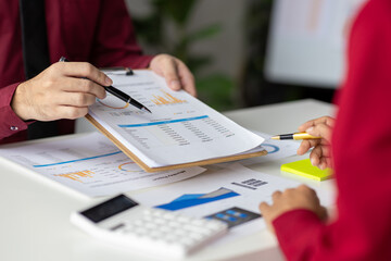 Business consultant analyzing financial data on report with charts and graphs. Business colleague...