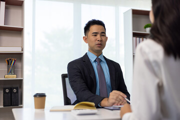 Manager interviewing a candidate for a job position in the office. Asian businessman in suit is...