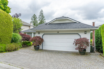 Garage door in luxury house with trees and nice landscape in Spring in Vancouver, Canada, North...