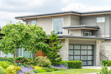 Garage door in luxury house with trees and nice landscape in Spring in Vancouver, Canada, North...