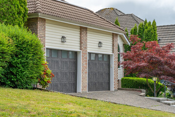Garage door in luxury house with trees and nice landscape in Spring in Vancouver, Canada, North...