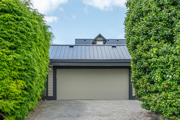 Garage door in luxury house with trees and nice landscape in Spring in Vancouver, Canada, North...