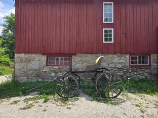 Red Barn with Historic Horse Carriage in Rural Setting