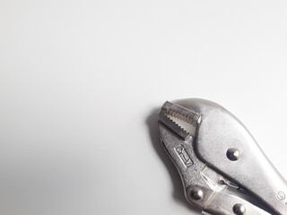 A vice grip or locking pliers, also known as a vice grip or locking pliers, is isolated on a white background. This tool is designed to grip and hold very strong objects.