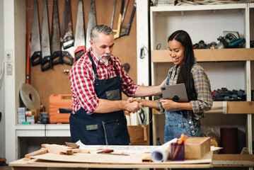 Carpentry Team Planning Wood Furniture Design, Senior Caucasian Man and Asian Woman Working...