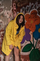 Portrait of a young dark-haired girl in a yellow jacket and yellow boots.