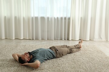 Harmony. Man lying on rug at home