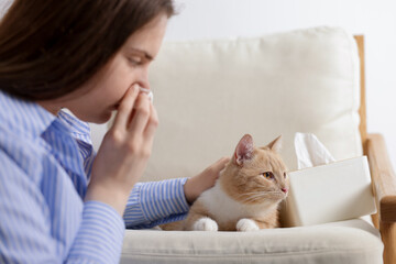 Woman suffering from allergy with her cat at home