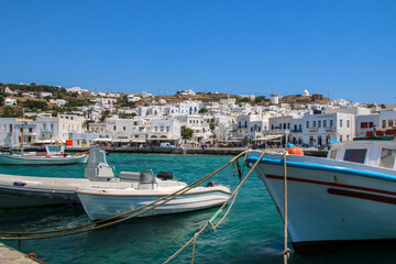 Obraz premium Boats in a Mykonos harbor with a landscape of the island