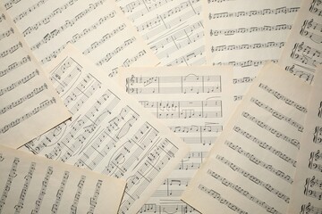 Sheets with musical notes as background, top view