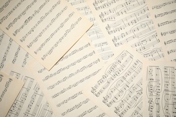 Sheets with musical notes as background, top view