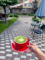Woman holds matcha cup outside. Peaceful mornings and natural energy boost, slow living, self-care, wellness, health, tea culture and everyday rituals