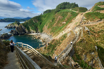 walkers climb the path over the cliffs at Punta do Fuciño do Porco