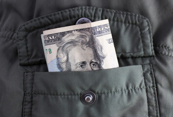 Twenty-dollar bill peeking out of a pocket