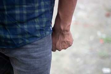 A young boy holds his waist with one hand for pain