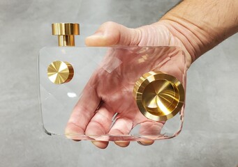 Handheld view of a modern, clear acrylic see-through camera model with gold details.