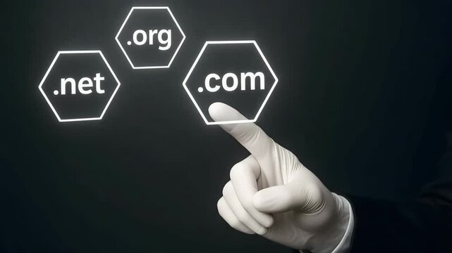 A white-gloved finger points toward glowing hexagons reading .com, .net and .org. Concept of domain registration and web identity.