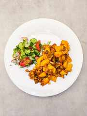 Delicious roasted potatoes with fresh vegetable salad