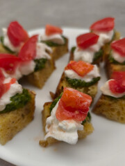 Delicious bruschetta with fresh tomato, mozzarella and pesto topping