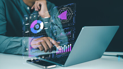 A person interacting with futuristic digital data visualizations projected from a laptop, analyzing...