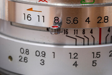 Exploring the intricate details of a vintage camera lens, highlighting its aperture, shutter speed, and various control settings