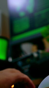 Slow motion shot of a hand typing on a keyboard in a dark hacker-themed setup with green code glowing on screens, creating a cinematic cyberpunk atmosphere.