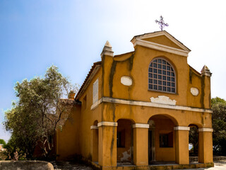 Fototapeta premium Yellow chapel with portico and olive tree in Corsican countryside France, Corsica, Ajaccio, 13 June 2025