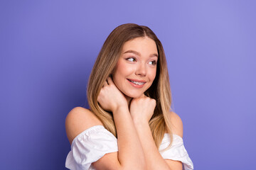 Charming young woman smiling with a cheerful expression wearing a stylish white top against a...