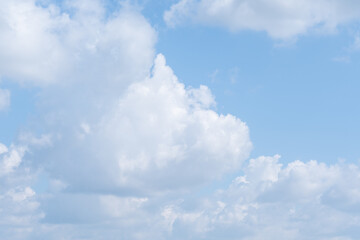 Fluffy white clouds scattered across bright blue sky on sunny day. concept of peace and calm