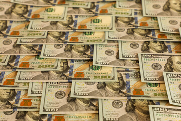 Neatly laid out US $100 bills with Benjamin Franklin’s portrait, rich colors, and security details, representing wealth, financial success, and prosperity.