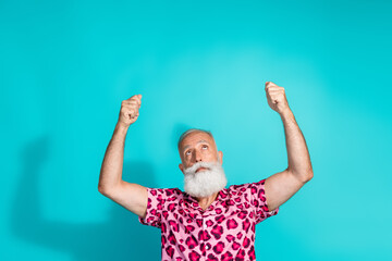 Portrait of funky aged man look up hold empty space poster wear leopard print costume isolated on...