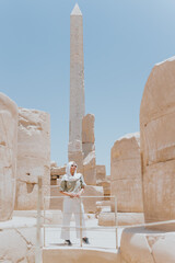 Tourist exploring karnak temple with majestic obelisk in luxor, egypt
