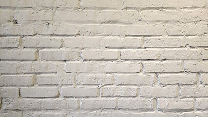 old brick wall The white painted brick wall has traces of time and uneven layout.