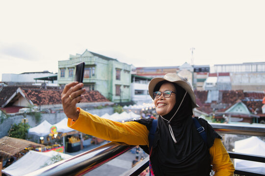 Smiling Woman Taking a Selfie Outdoors at Teras Malioboro in Sunny Day
