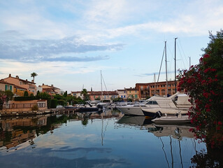 Stunning sunset view of a peaceful Mediterranean harbor, with pastel-colored houses lining a...