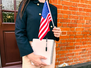 Young woman with American flag and textbook, concept of learning English