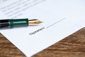 Notary document and fountain pen on wooden table, closeup