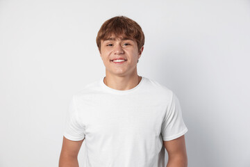 Portrait of smiling teenage boy on light grey background