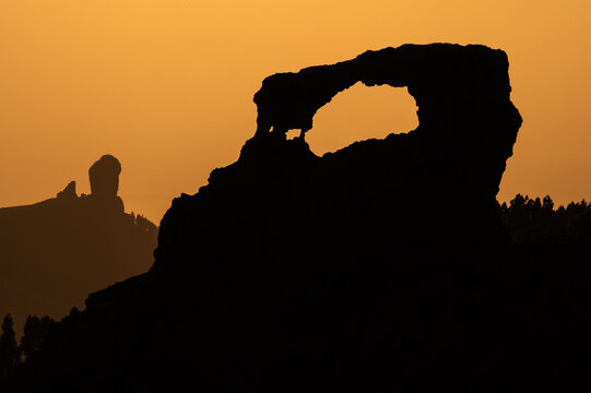 View of Ga&ntilde;ifa rock window with Roque Nublo rock during sunset from Pozo del Pico de Las Nieves viewpoint in Gran Canaria, Canary Islands, Spain