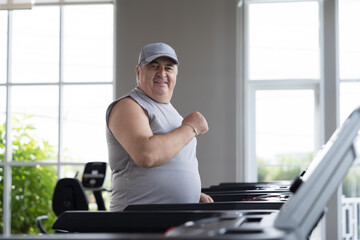 Man running on treadmill in gym. Mature male running on treadmill machine. Fitness, gym and exercising
