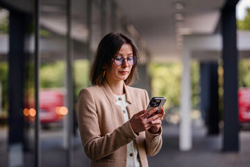 Professional Woman Using Smartphone in Modern Office Space