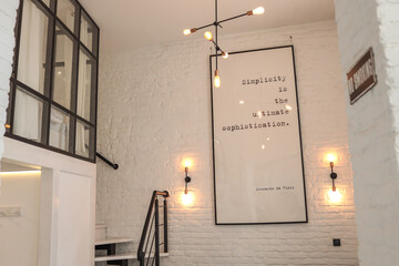 Modern loft interior with white brick walls, glass partition, minimal staircase, and a framed...