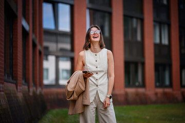 Fototapeta premium Happy Businesswoman Laughing Outdoors with Phone