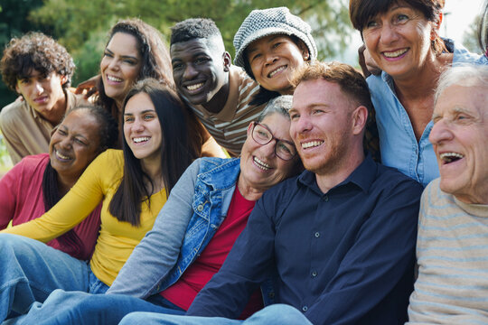 Group of multiracial people having fun hugging each other at city park - Diversity, multi generational friends and community concept