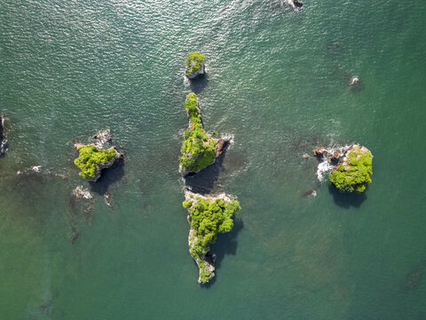 Aerial view of Bota Island's rocky outcrops cloaked in verdant vegetation amid the Limbe River's emerald expanse, Limbe, South West, Cameroon.