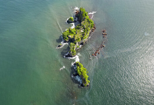 Aerial view of Bota Island's rugged cliffs and verdant foliage meet the turquoise waters of the Limbe River, creating a mesmerizing contrast, Limbe, South West, Cameroon.